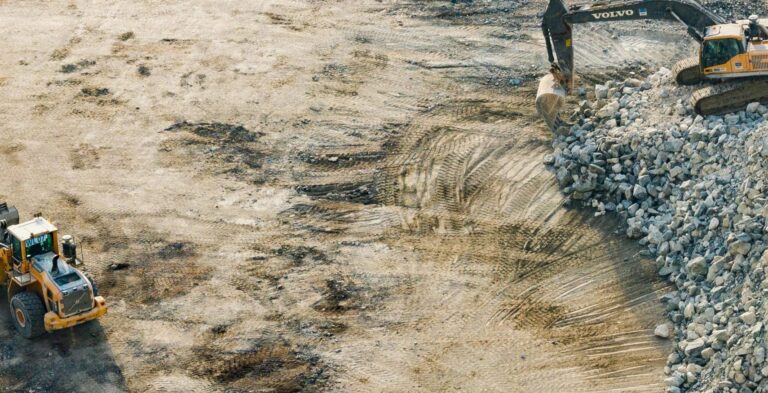Excavator and bulldozer clearing away the soil