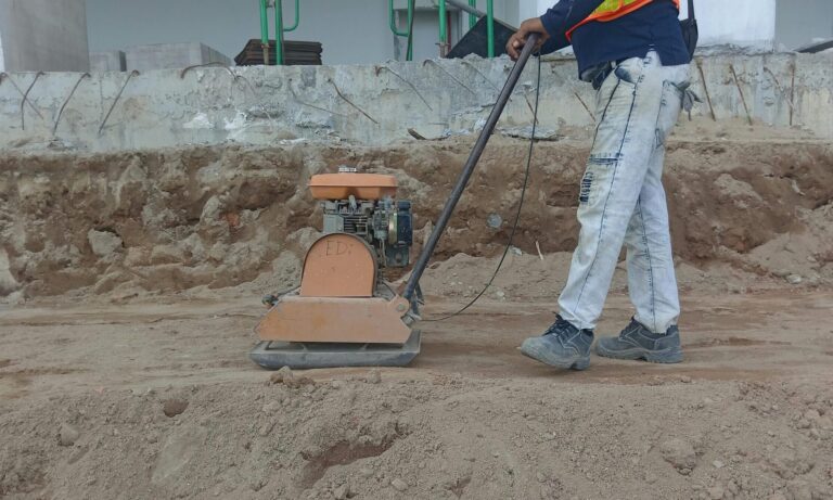 Worker plaining land with equipment