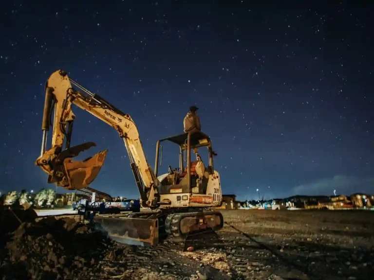 Brooklyn construction site with cranes working on excavation services at night